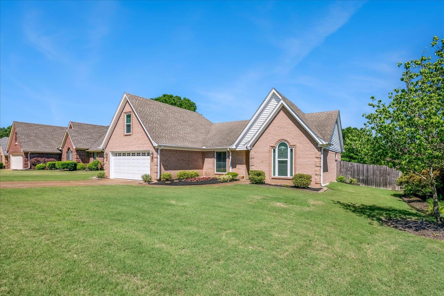 4654 Shadow Wick Lane Bartlett, TN 38002 - Photo 3 of 26 Brick exterior with white trim, featuring an attached garage and pitched rooflines