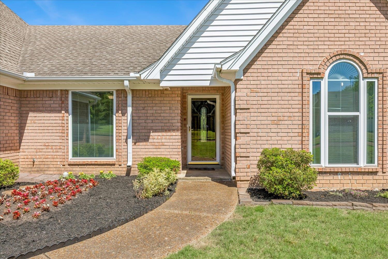 4654 Shadow Wick Lane Bartlett, TN 38002 - Photo 5 of 26 Brick exterior with an arched window, a gabled entrance, and a paved walkway
