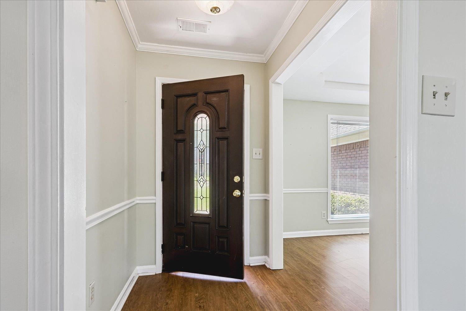 4654 Shadow Wick Lane Bartlett, TN 38002 - Photo 6 of 26 Entryway featuring a dark wood-finish door with decorative glass, wood-finish flooring, crown molding, and wainscoting