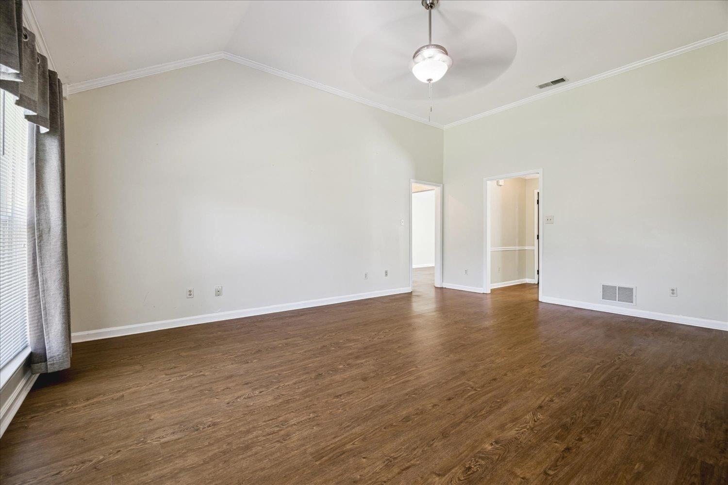 4654 Shadow Wick Lane Bartlett, TN 38002 - Photo 9 of 26 Spacious room featuring vaulted ceilings, wood-finish flooring, and crown molding