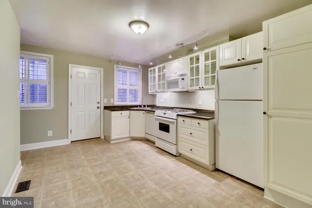 a kitchen with granite countertop cabinets and white appliances