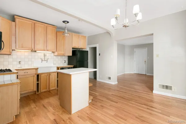 a kitchen with a refrigerator a stove top oven a sink and dishwasher with wooden floor