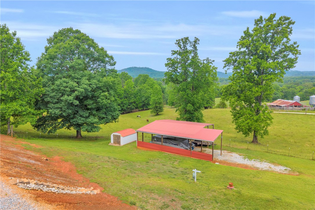 721 Cedar Crest Trail Walhalla, SC 29691 - Photo 37 of 47 Sprawling green acreage with mountains in the background, complete with a shed and a covered structure.