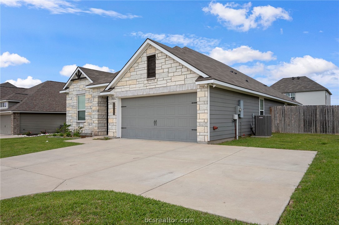 Charming curb appeal with stone accents, covered entry, and welcoming front lawn.