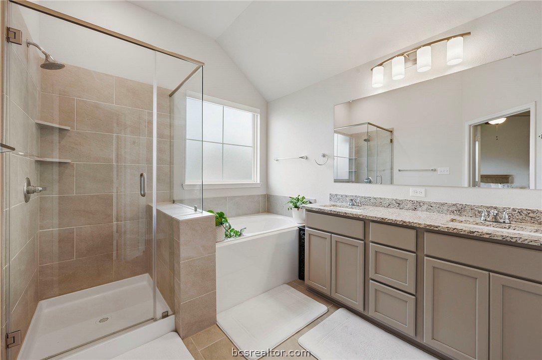 2038 Viva Road Bryan, TX 77807 - Photo 12 of 21 Well-appointed primary bath with dual vanities, soaking tub, and separate shower.