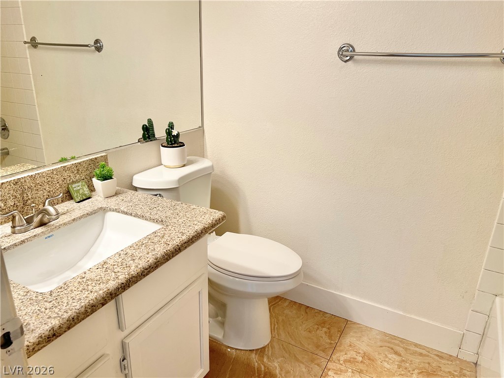 9708 Ridge Creek Place Las Vegas, NV 89134 - Photo 16 of 34 A pristine bathroom features a vanity with granite counters and a clean commode.
