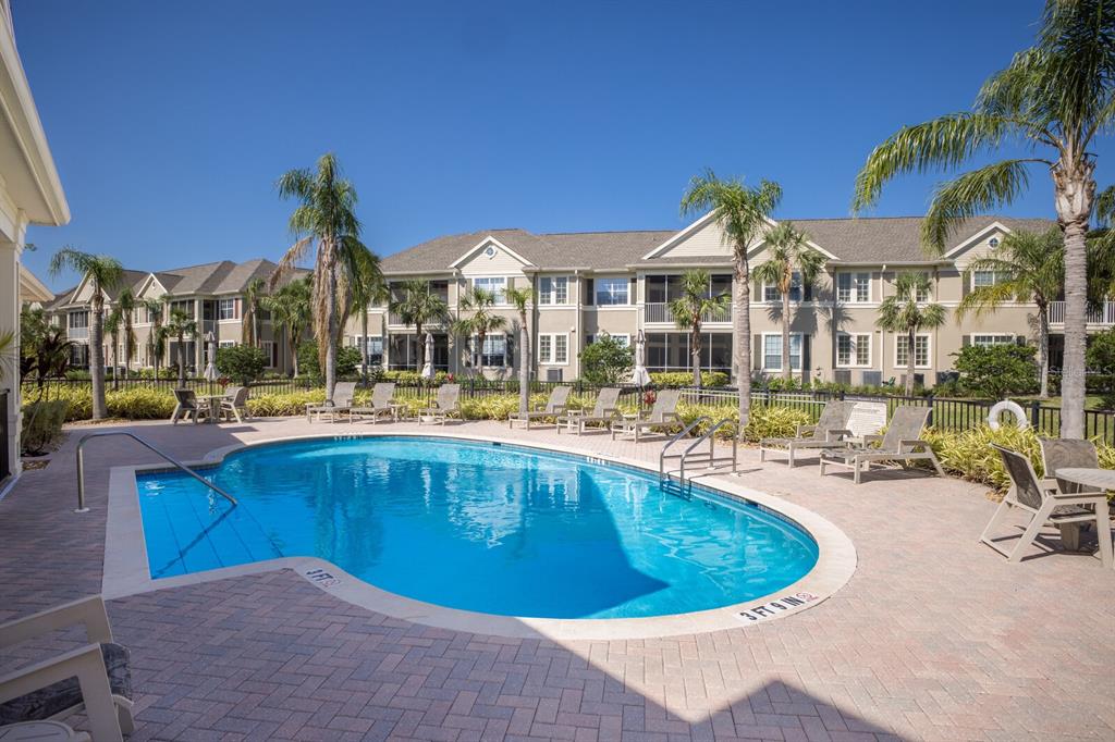 8035 St Simons Street, Unit 8035 University Park, FL 34201 - Photo 33 of 39 a view of a swimming pool with a lawn chairs under an umbrella