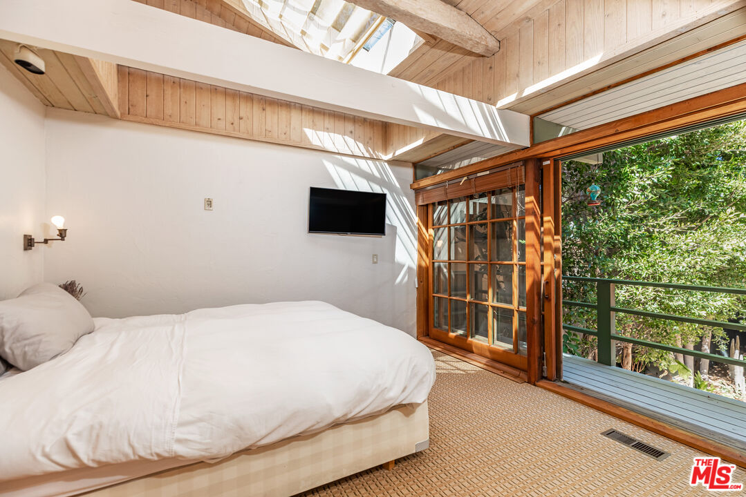 23441 Malibu Colony Road Malibu, CA 90265 - Photo 21 of 43 a bedroom with a large bed and a tv