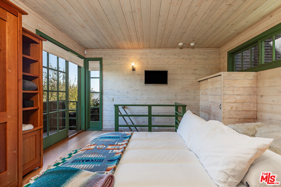 23441 Malibu Colony Road Malibu, CA 90265 - Photo 34 of 43 a bedroom with a bed and a flat screen tv