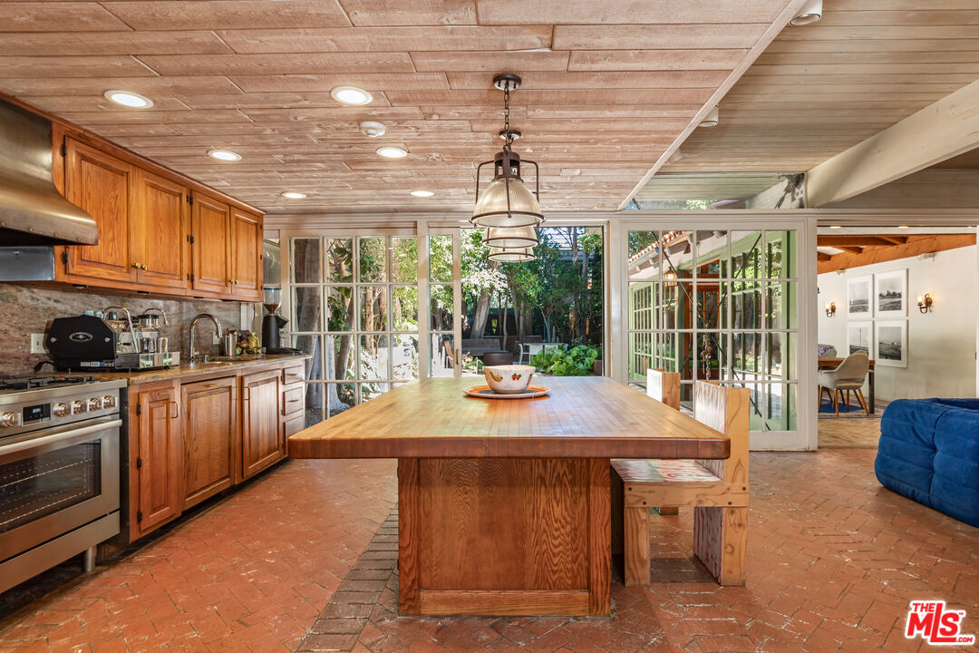 23441 Malibu Colony Road Malibu, CA 90265 - Photo 7 of 43 a kitchen with kitchen island a stove a counter space a sink and cabinets