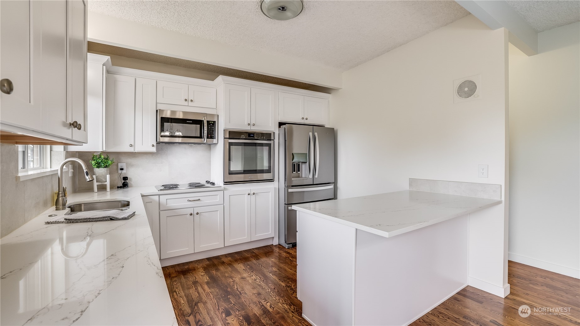 678 Sunset Boulevard Northeast Renton, WA 98056 - Photo 8 of 31 a kitchen with stainless steel appliances granite countertop a sink a stove a refrigerator a microwave oven with white cabinets