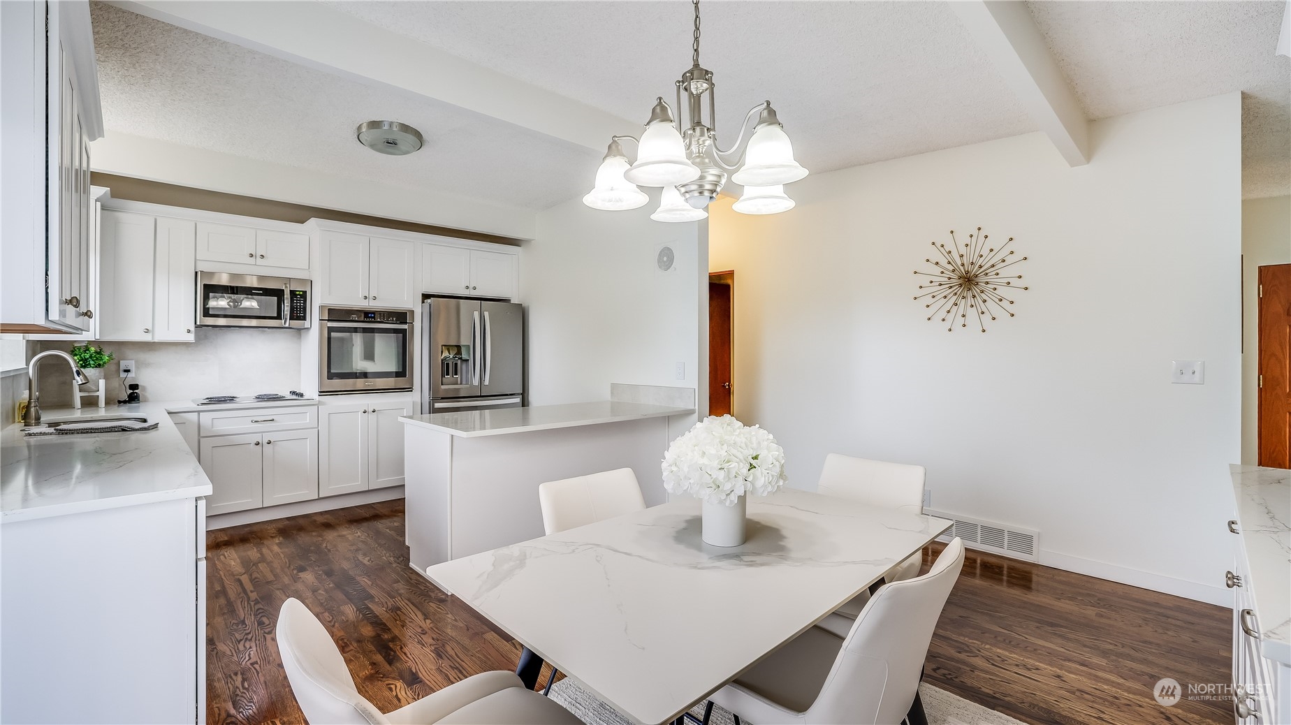 678 Sunset Boulevard Northeast Renton, WA 98056 - Photo 9 of 31 a kitchen with stainless steel appliances kitchen island granite countertop a table chairs and a refrigerator