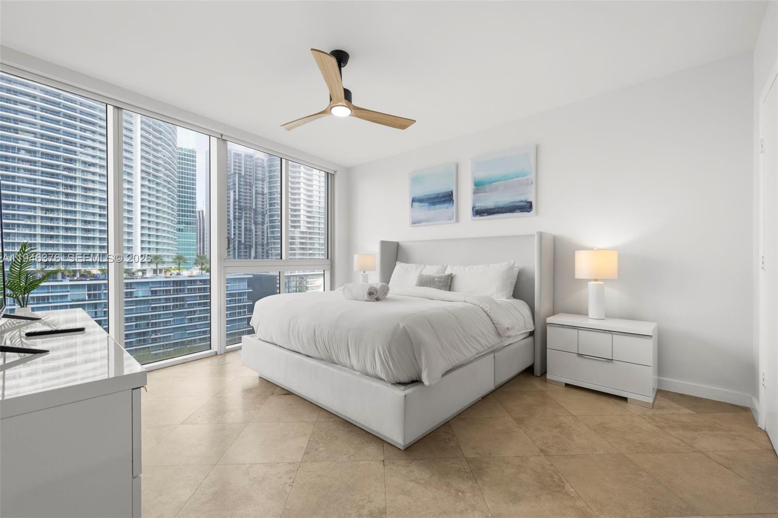 485 Brickell Avenue, Unit 1804 Miami, FL 33131 - Photo 12 of 60 a bedroom with a large bed and a chandelier