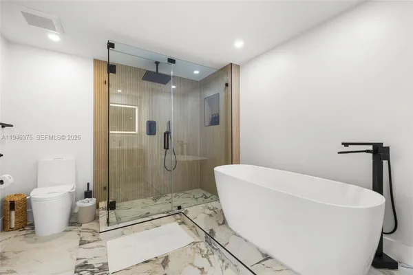 a bathroom with a sink a toilet and shower