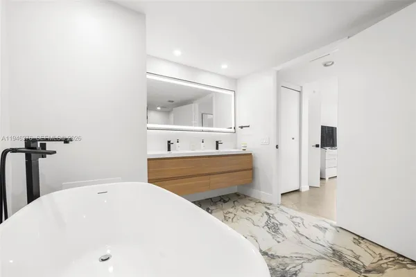 a bathroom with a tub sink and mirror
