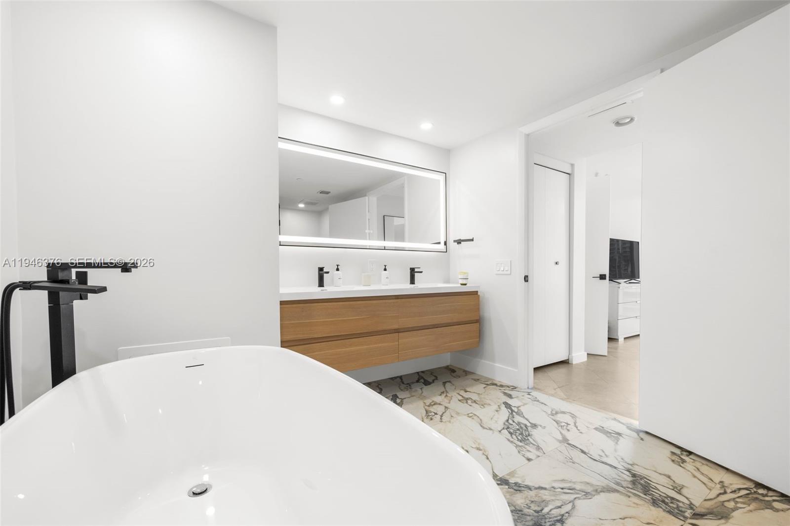 485 Brickell Avenue, Unit 1804 Miami, FL 33131 - Photo 21 of 60 a bathroom with a tub sink and mirror