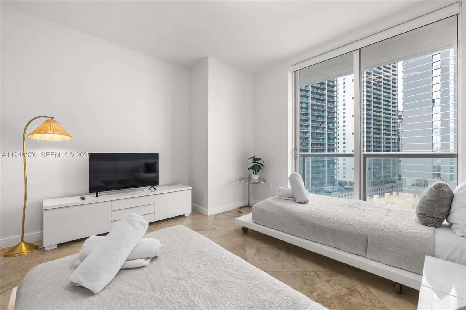 485 Brickell Avenue, Unit 1804 Miami, FL 33131 - Photo 24 of 60 a bedroom with a bed and glass wall