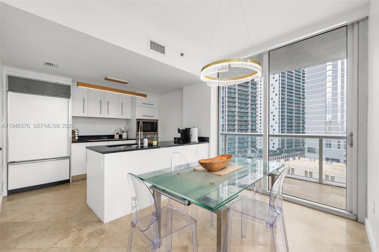 485 Brickell Avenue, Unit 1804 Miami, FL 33131 - Photo 6 of 60 a kitchen with stainless steel appliances granite countertop a stove a refrigerator a microwave oven with white cabinets and wooden floor