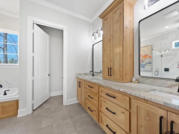 a spacious bathroom with a granite countertop sink and a mirror