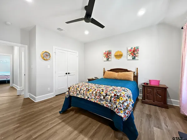 a bedroom with a bed and wooden floor