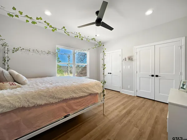 a bedroom with a bed chandelier and a window