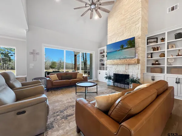 a living room with furniture a fireplace and a large window
