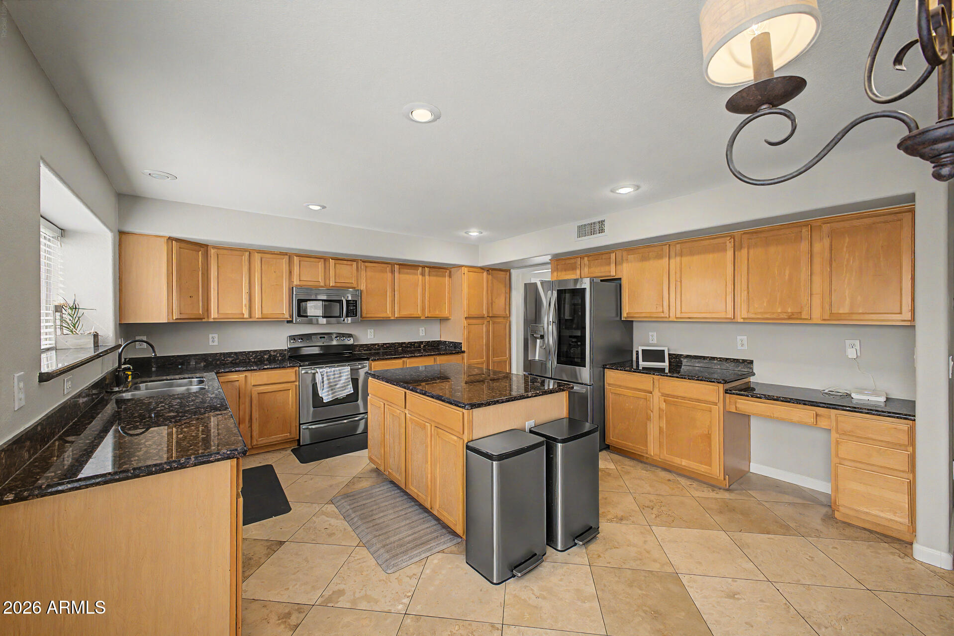 1306 East Erie Street Gilbert, AZ 85295 - Photo 21 of 62 a kitchen with stainless steel appliances granite countertop a stove top oven a sink a counter top space and cabinets