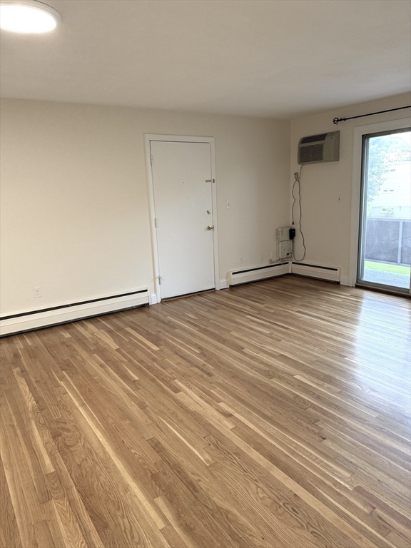 25 Lionel Avenue, Unit E Waltham, MA 02452 - Photo 11 of 13 a view of an empty room with wooden floor and a window