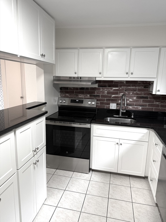 25 Lionel Avenue, Unit E Waltham, MA 02452 - Photo 2 of 13 a kitchen with white cabinets and appliances