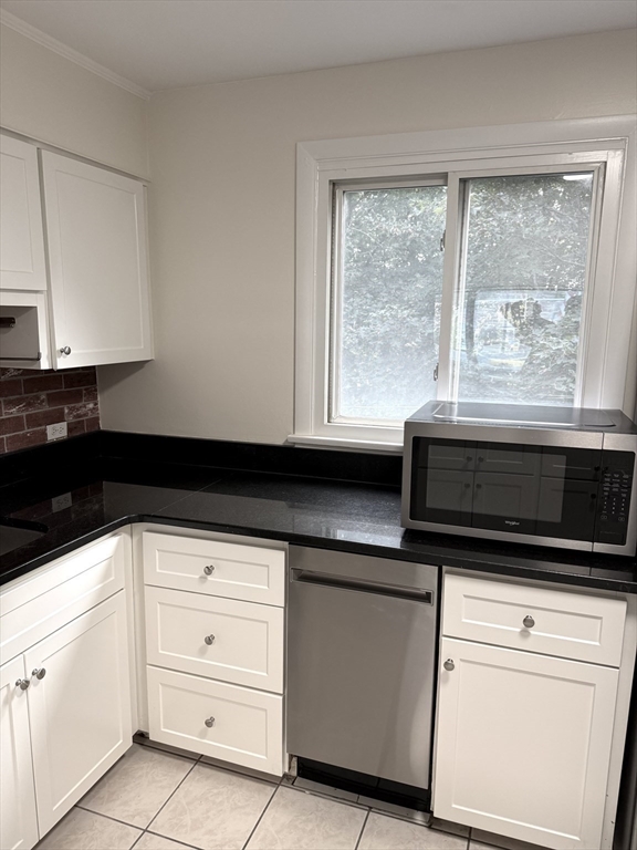 25 Lionel Avenue, Unit E Waltham, MA 02452 - Photo 3 of 13 a kitchen with white cabinets and appliances