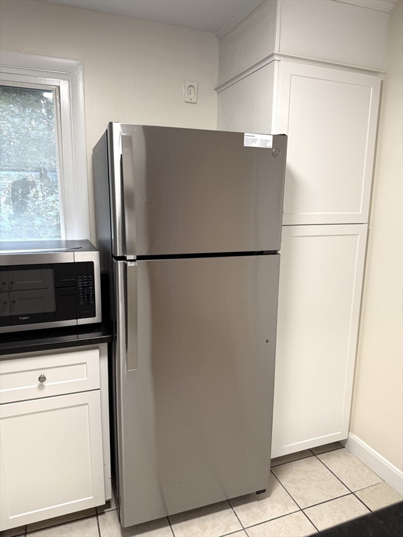 25 Lionel Avenue, Unit E Waltham, MA 02452 - Photo 4 of 13 a white refrigerator freezer and a stove sitting inside of a kitchen