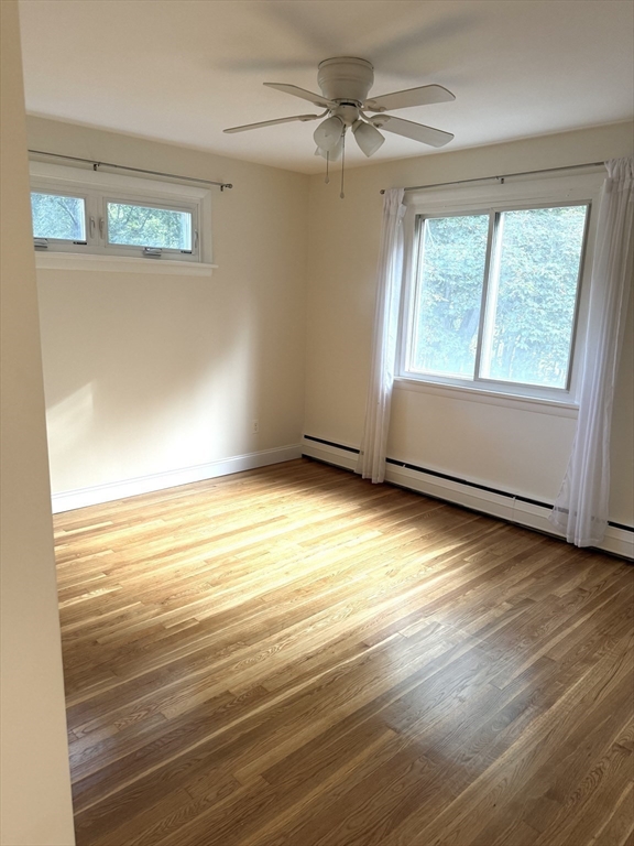 25 Lionel Avenue, Unit E Waltham, MA 02452 - Photo 6 of 13 a view of an empty room with wooden floor and a window