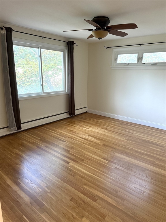 25 Lionel Avenue, Unit E Waltham, MA 02452 - Photo 8 of 13 a view of an empty room with wooden floor and a window