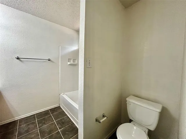 a white toilet sitting next to a shower