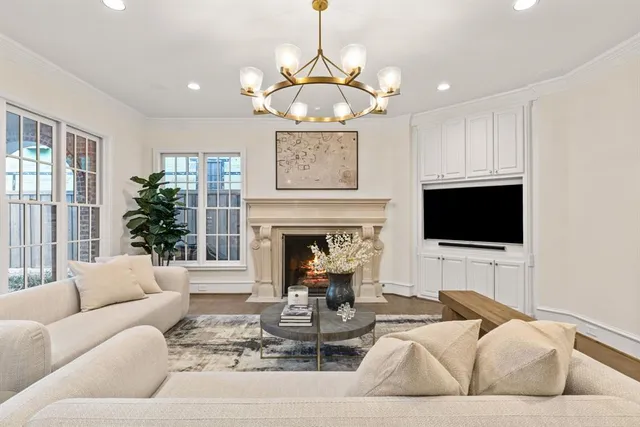 a living room with furniture a chandelier and a fireplace
