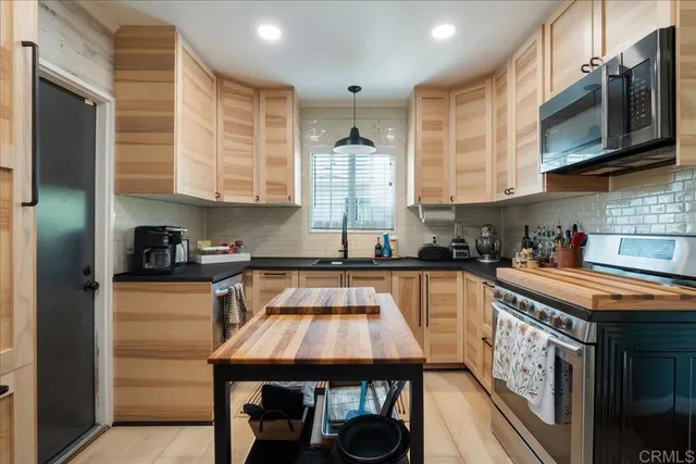 a kitchen with stainless steel appliances granite countertop a sink a stove and cabinets