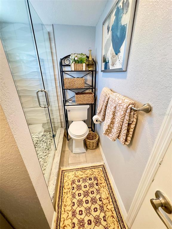 8911 Blind Pass Road, Unit 220 St. Pete Beach, FL 33706 - Photo 35 of 67 a bathroom with a toilet and a shower