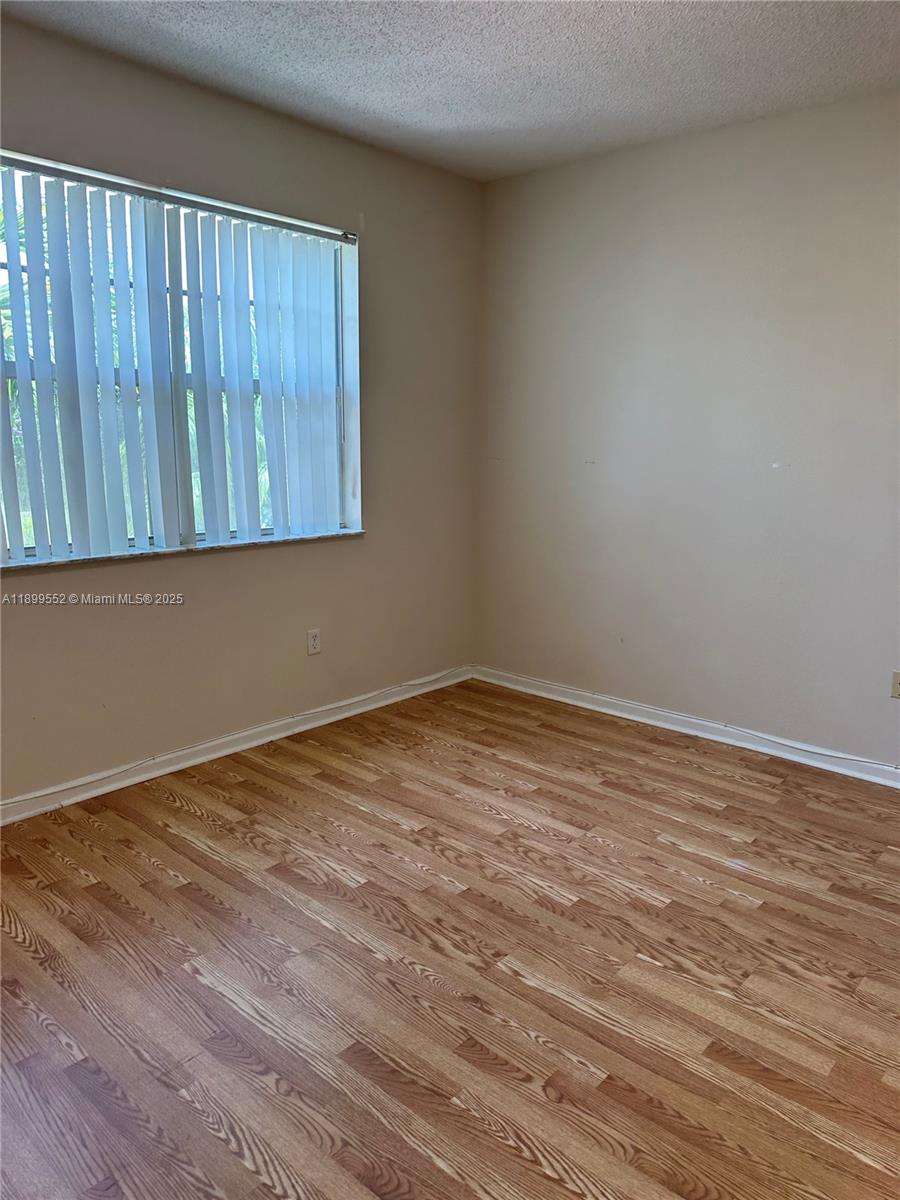 5840 West Sample Road, Unit 306 Coral Springs, FL 33067 - Photo 4 of 22 a view of an empty room with wooden floor
