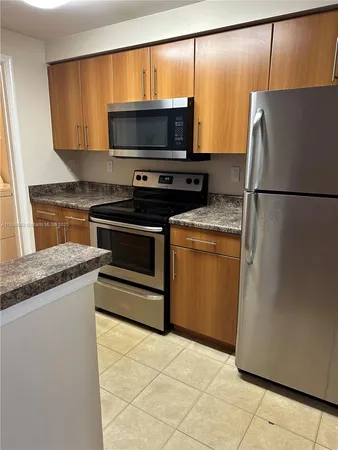 a kitchen with a refrigerator and a microwave