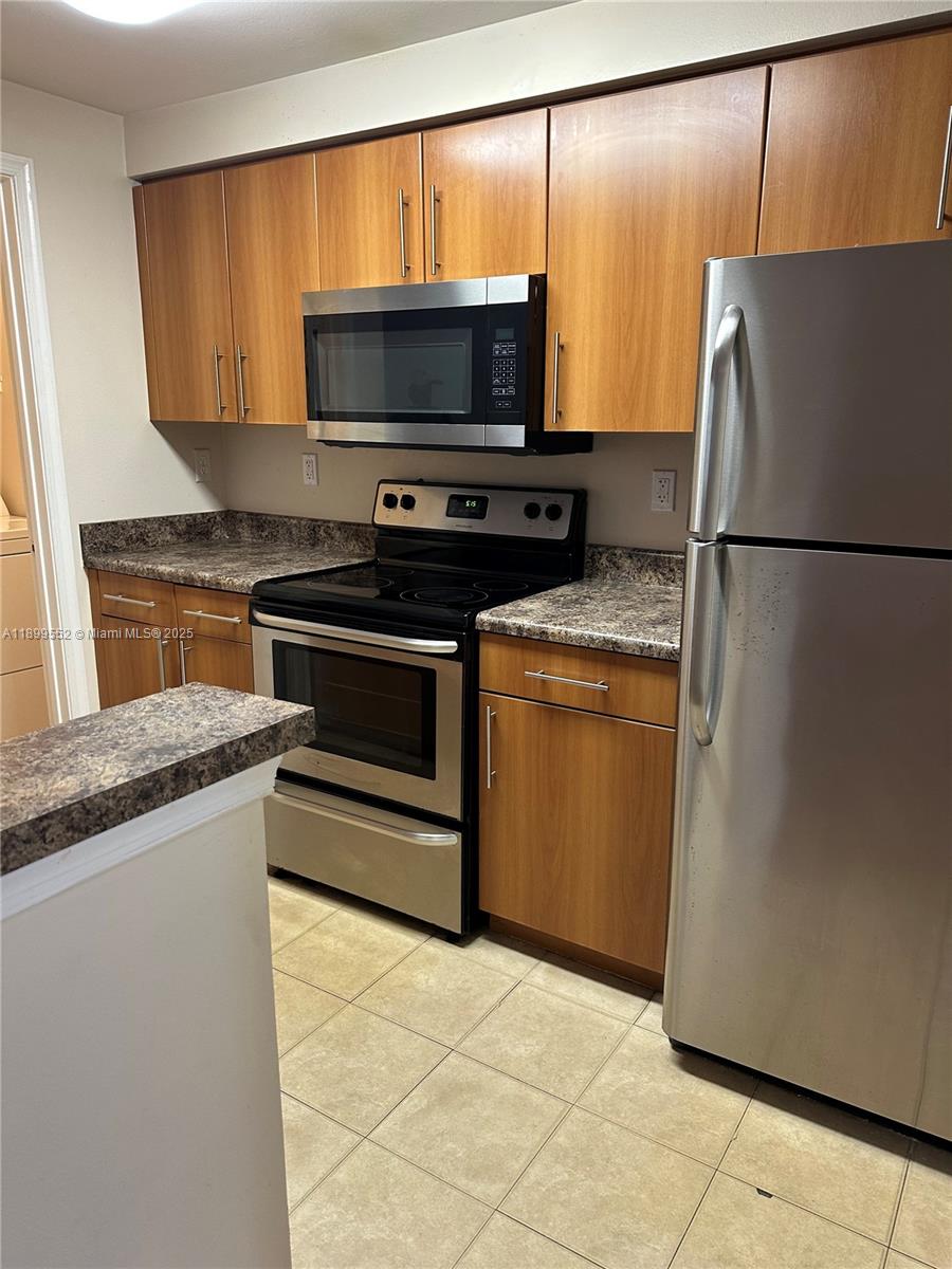 5840 West Sample Road, Unit 306 Coral Springs, FL 33067 - Photo 6 of 22 a kitchen with a refrigerator and a microwave