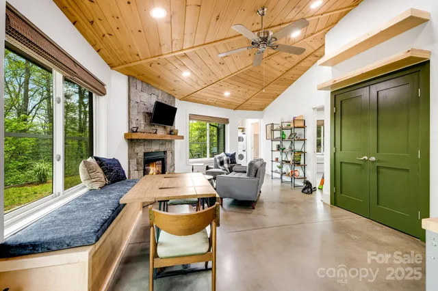 a living room with fireplace furniture and a large window
