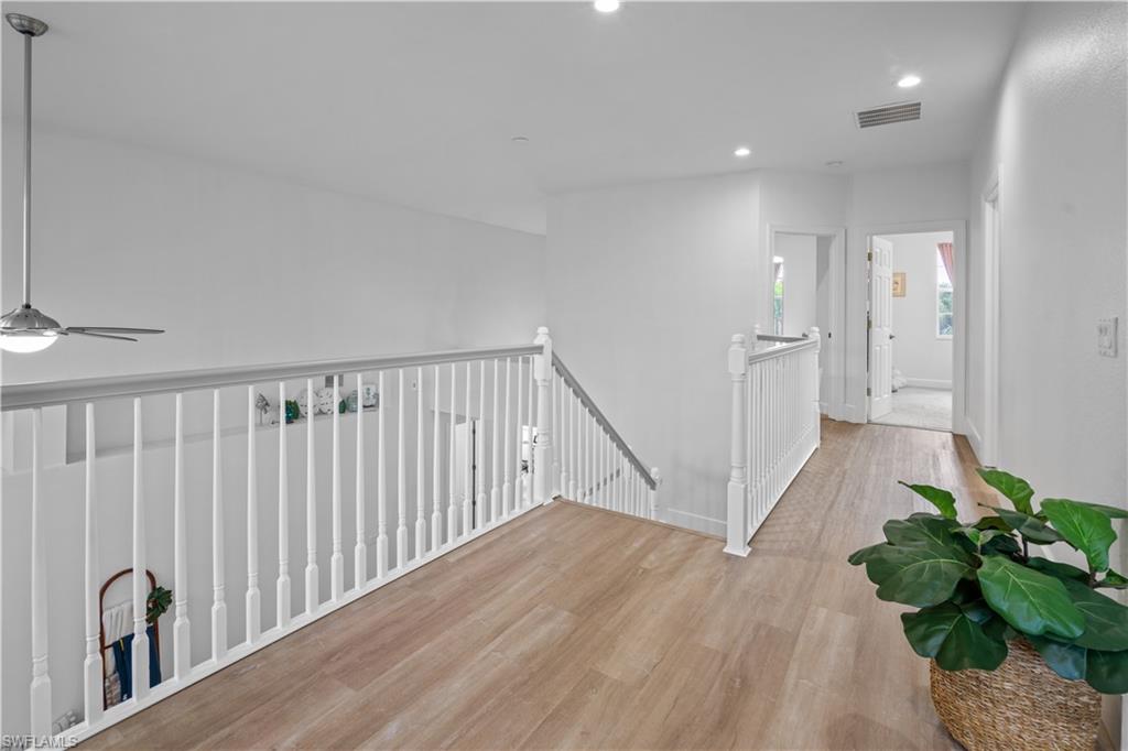 15917 Delasol Lane Naples, FL 34110 - Photo 21 of 32 a view of a hallway with wooden floor and stairs