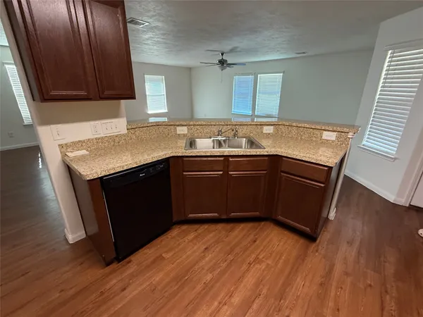 a kitchen with a sink and wooden floor