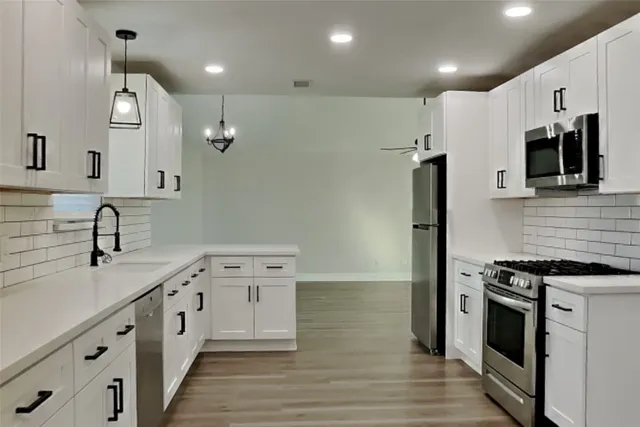 a kitchen with stainless steel appliances a sink stove and refrigerator