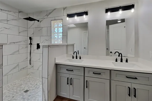 a bathroom with a sink vanity granite shower and a mirror