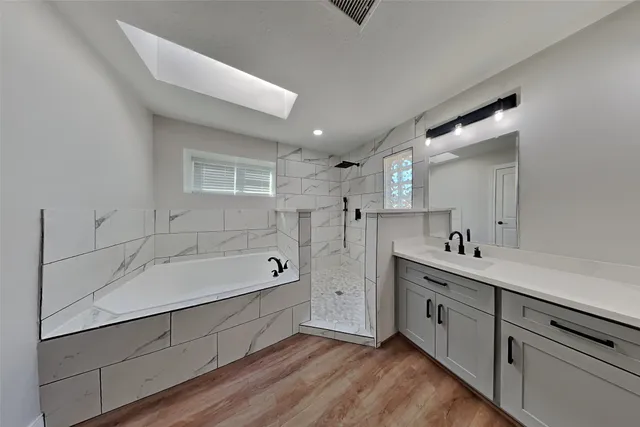 a bathroom with a tub sink and mirror