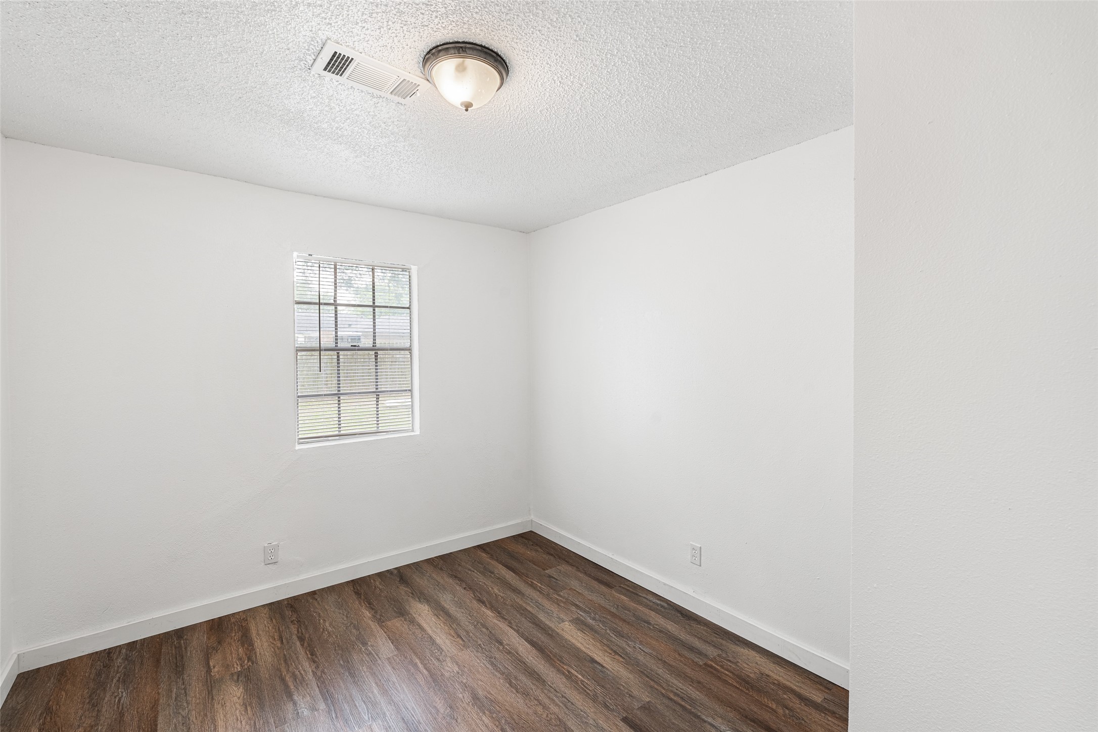 9005 Gabriel Street Houston, TX 77063 - Photo 12 of 21 an empty room with wooden floor and windows