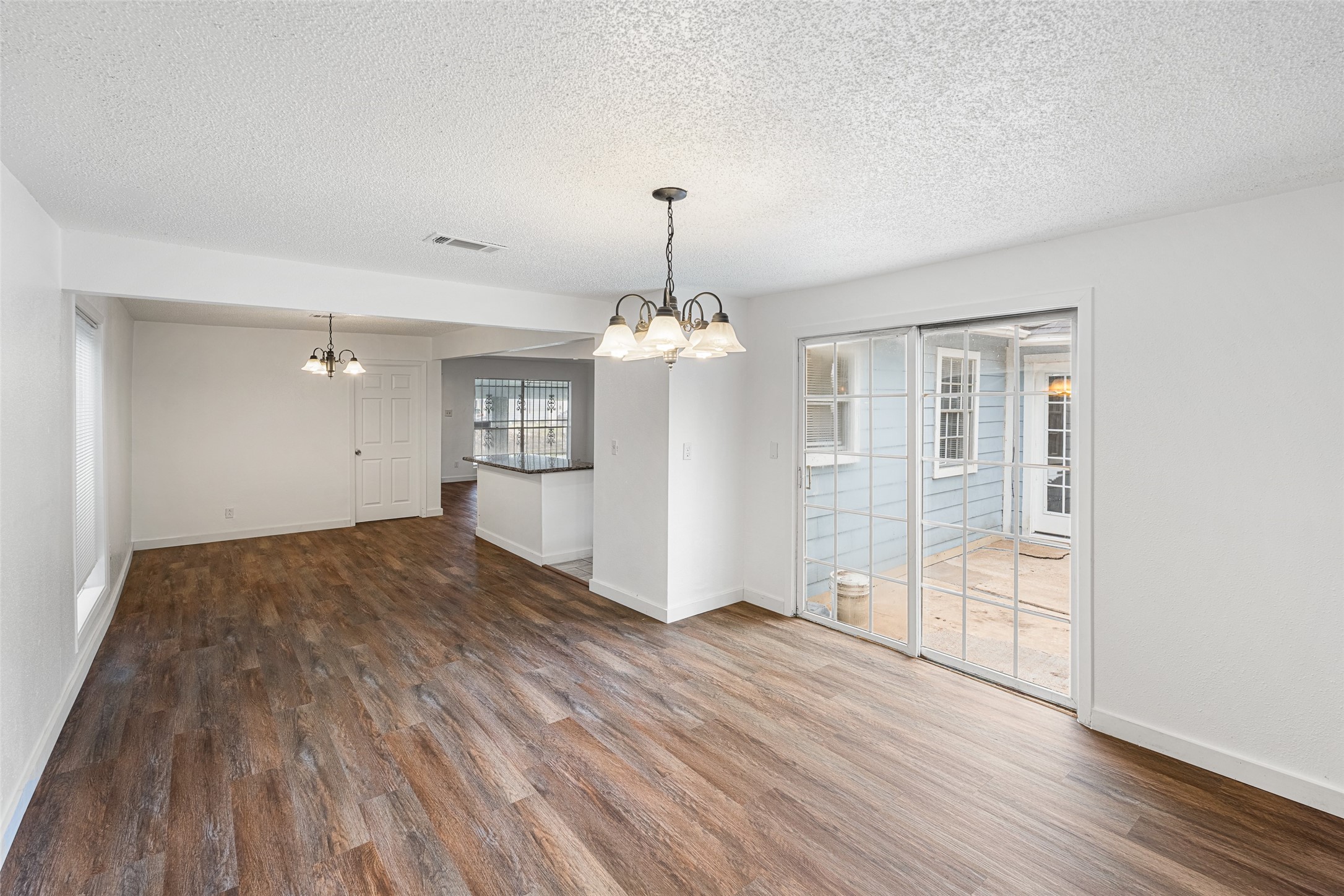 9005 Gabriel Street Houston, TX 77063 - Photo 4 of 21 an empty room with wooden floor chandelier and windows