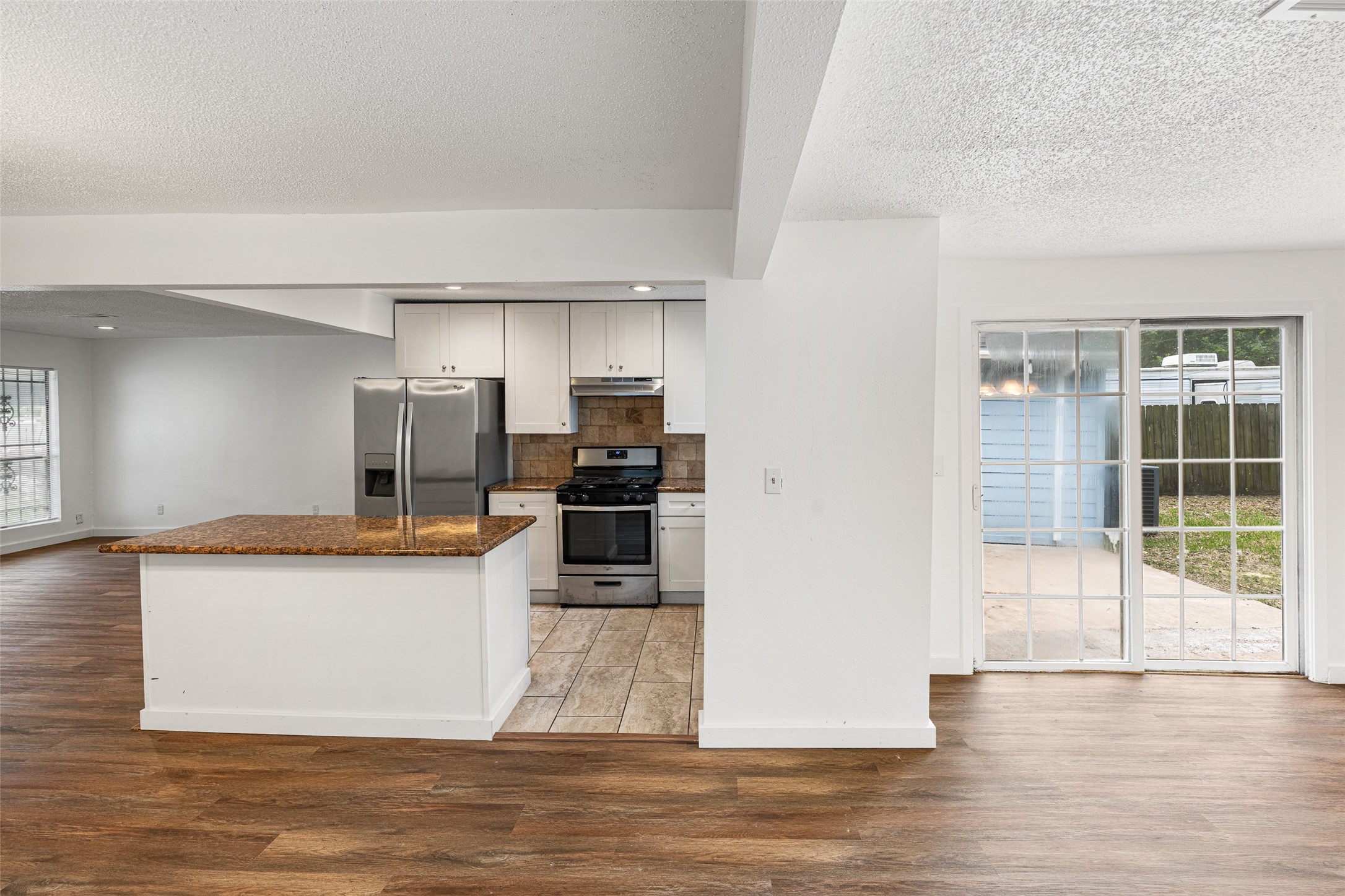 9005 Gabriel Street Houston, TX 77063 - Photo 6 of 21 a kitchen with stainless steel appliances kitchen island granite countertop a refrigerator a sink a stove and oven with wooden floor