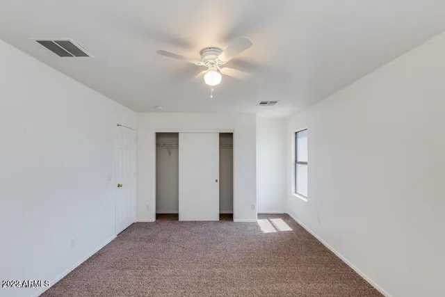 a view of a window and a chandelier fan in big room